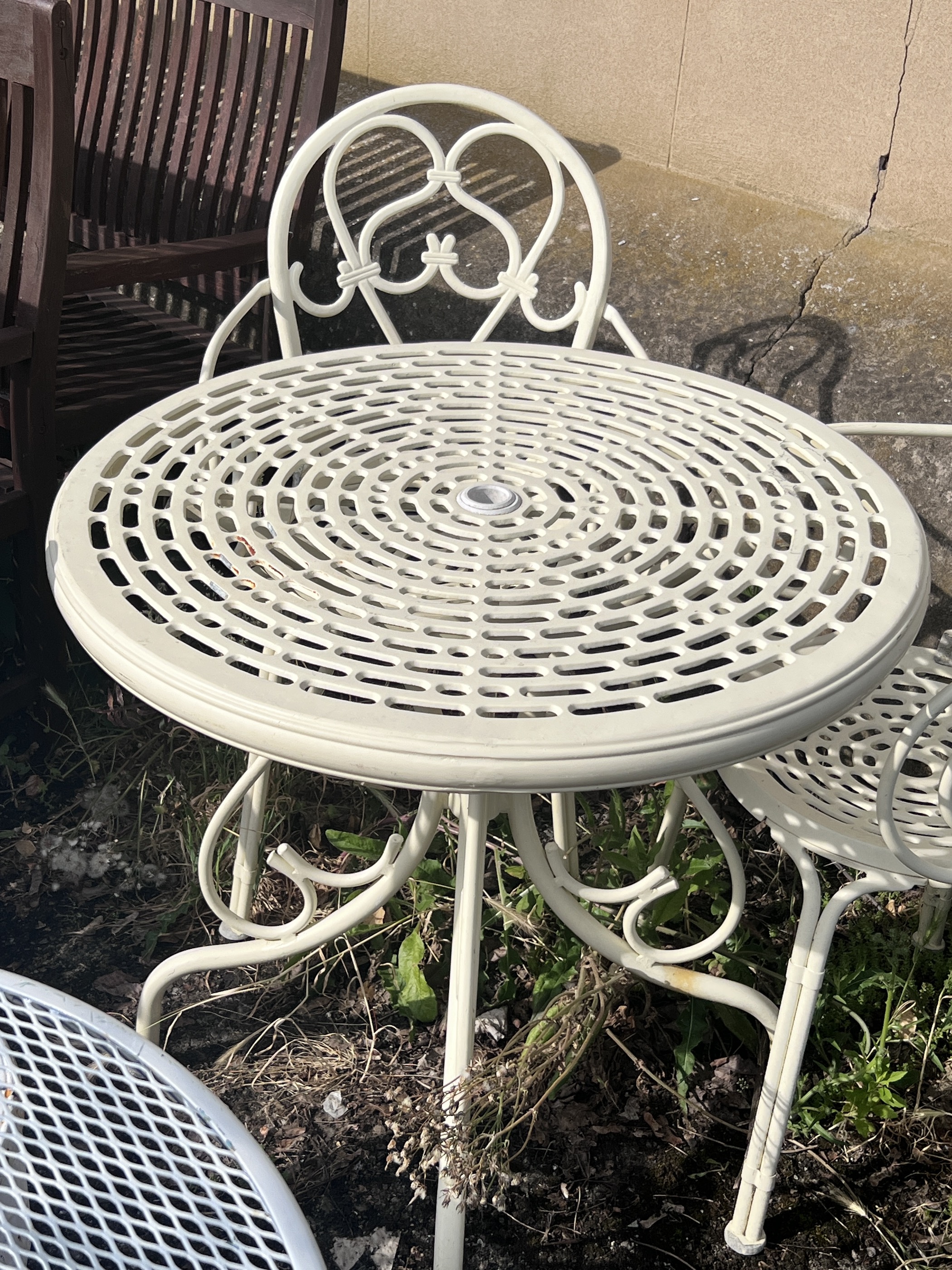 A circular aluminium garden table, diameter 74cm, height 73cm, and two elbow chairs